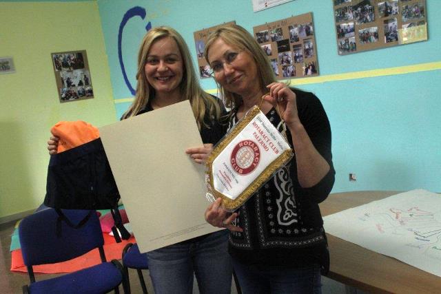 Una volontaria riceve il gagliardetto del Rotaract
