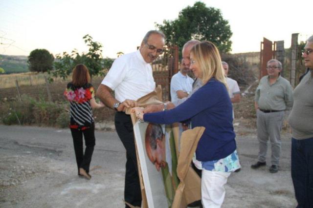 Rosalba Razzano, volontaria, porta il poster del Beato Puglisi per la Casa